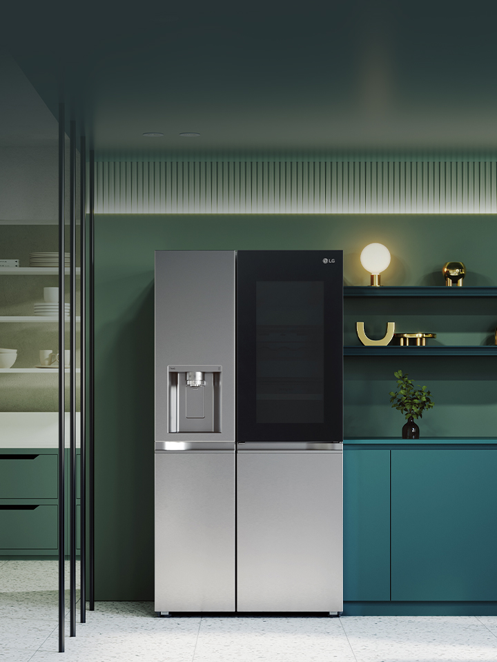 LG InstaView fridge freezer centered in a green kitchen with surrounding shelves sink and built-in appliances
