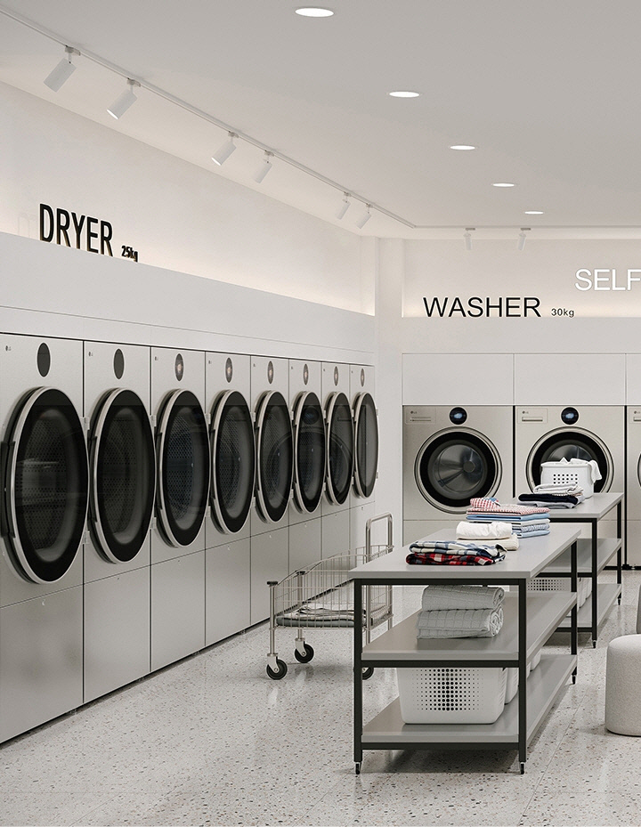 Symmetrical self service laundry layout with washers dryers, folding tables, and seating area