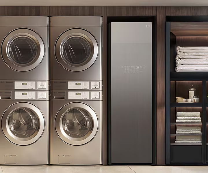 On-premises laundry room with stacked commercial washers, dryers, and neatly organized storage	