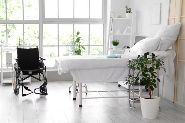 Bright healthcare room with a treatment bed and wheelchair, emphasizing hygiene and care	