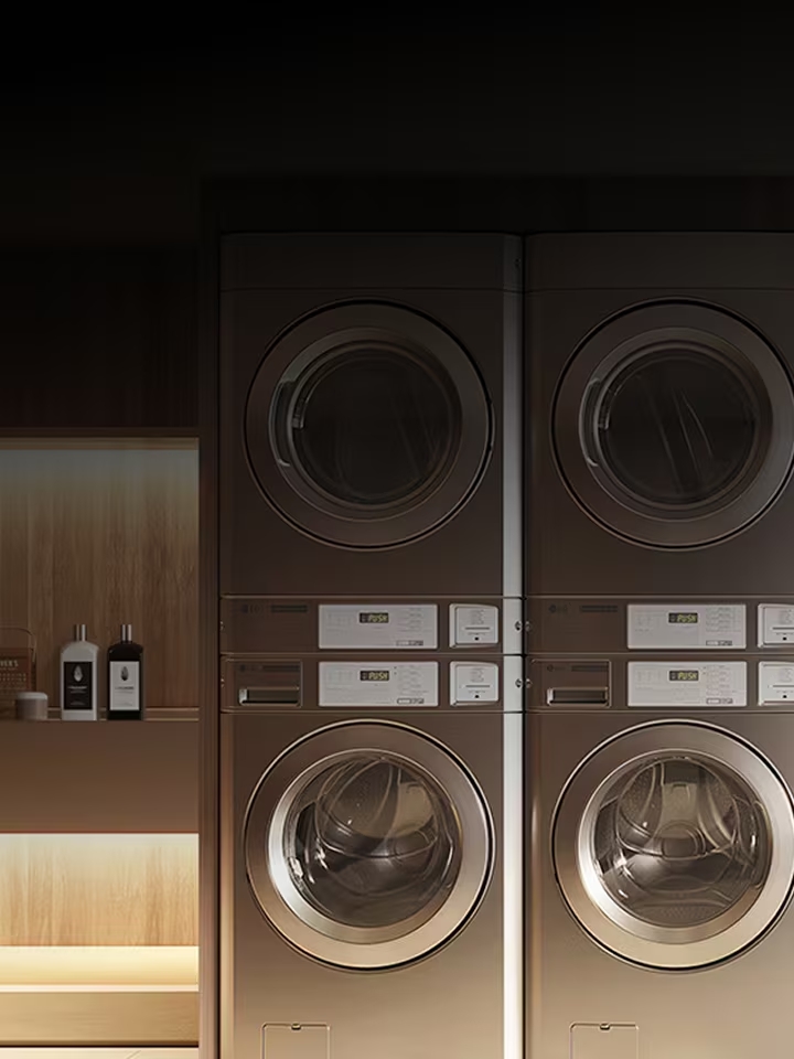 Premium commercial laundry setup with stacked washers and dryers in a dark, refined interior	