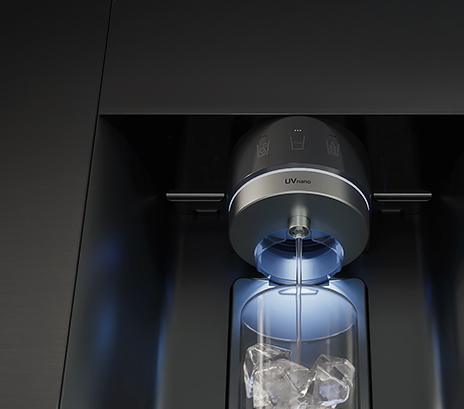 Water is flowing from a refrigerator dispenser labeled ‘UVnano,’ and the water is being poured into a cup.