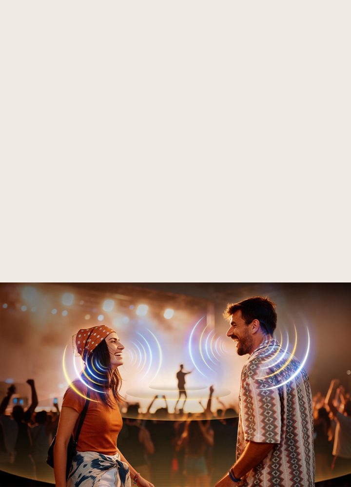 LG Micro RGB evo AI MRGB95 with AI Object Remastering Ultra shows two people facing each other at a crowded concert, clarifying voices amid loud background noise and delivering crystal-clear, immersive audio.