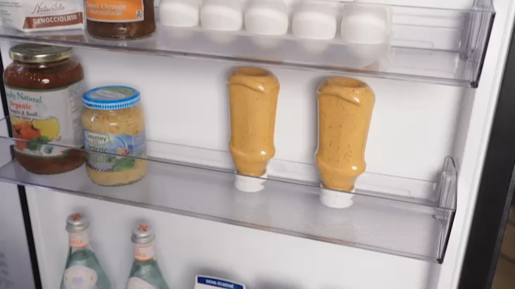 LG Fridge Freezer door with mini baskets holding sauces, jars, and beverages.
