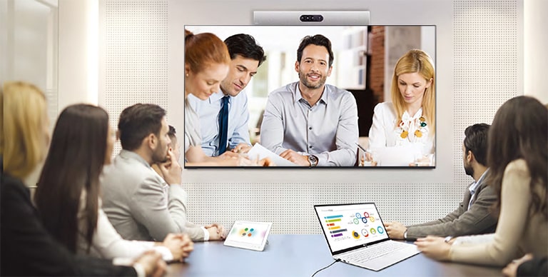A video conference is being held as people are screened on signage installed on the wall.