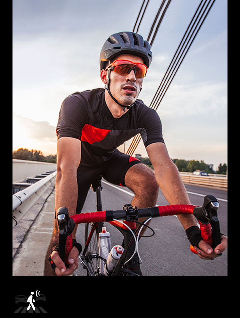 A man wearing TONE Free fit earbuds is riding on a bicycle.