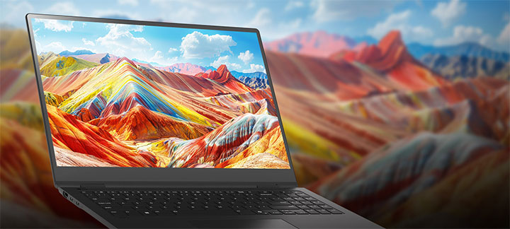 A laptop displaying a vivid and colourful landscape of vibrant mountains on its screen, emphasising high-resolution and rich colour reproduction. The background features a blurred version of the same landscape, drawing attention to the screen quality.