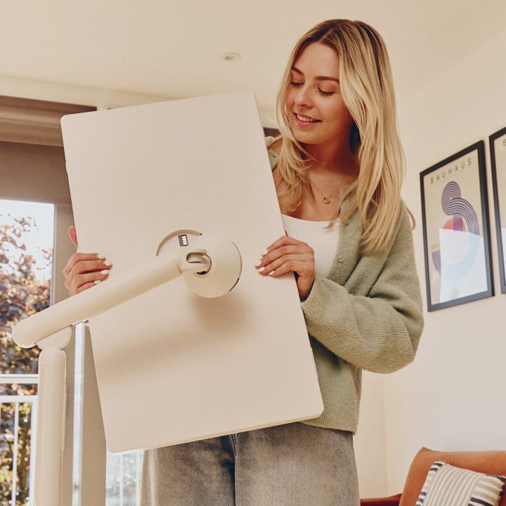 A woman detaching a StanbyME 2 smart screen from its stand.
