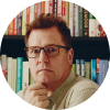 A small circular profile photo of a man wearing glasses, shown from the shoulders up against a neutral background.