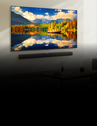 NanoCell TV mounted on the wall displays a bright scenic view of a lake with mountains and a red boat.