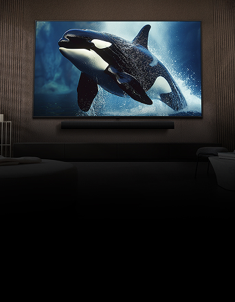 LG TV with an impressively large screen is mounted on a wall above an LG Soundbar in a modern-style living room.