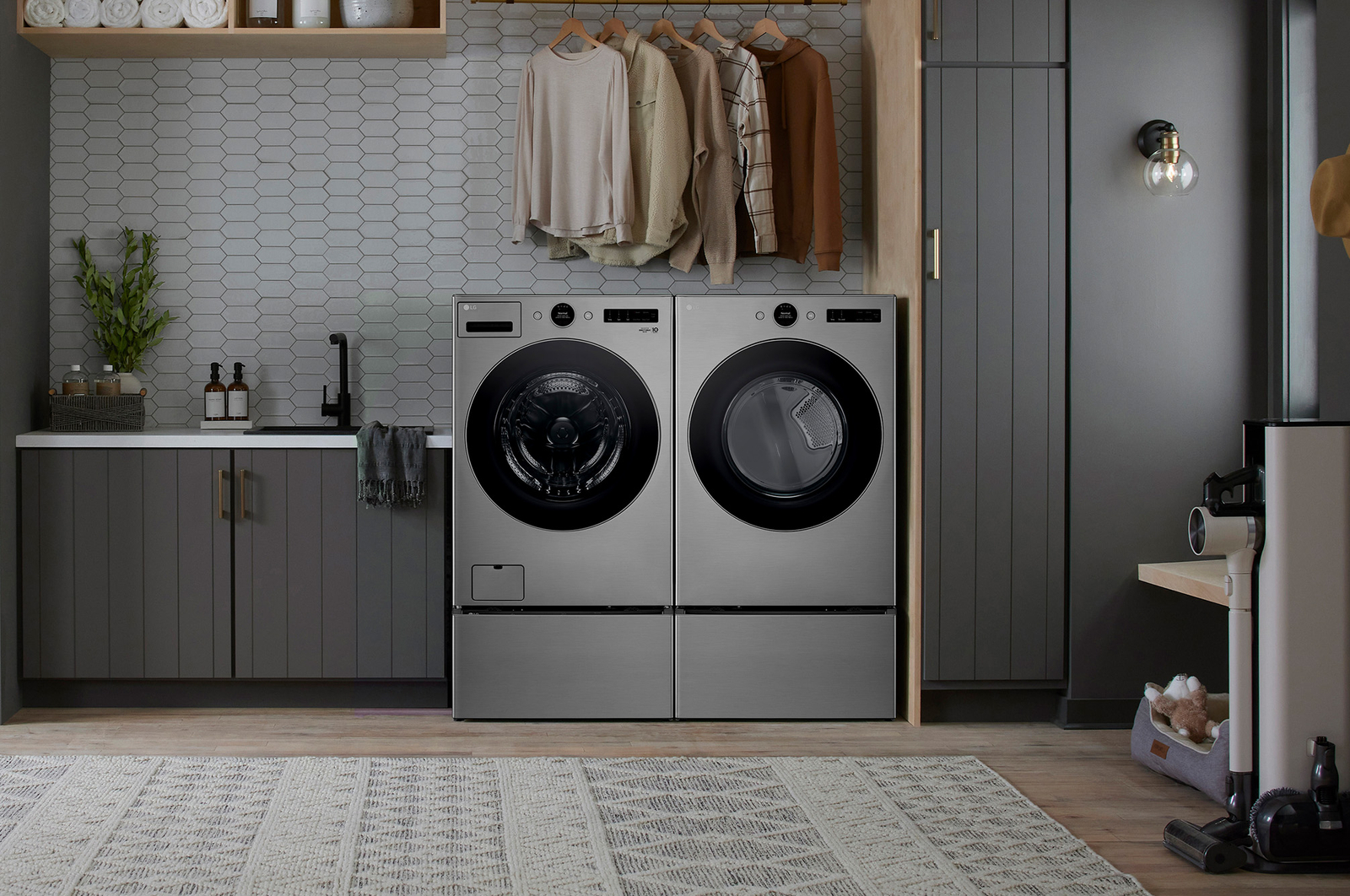 The Graphite Steel LG 7.4 cu.ft. dryer DLEX5500V, installed side-by-side with a matching washer on pedestals in a modern laundry room.