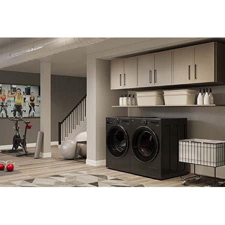 The LG Front Load Washer and Dryer set (DLHC6702B) in Black Steel, showcasing its premium aesthetic and seamless integration into a modern, multi-purpose utility and gym space.