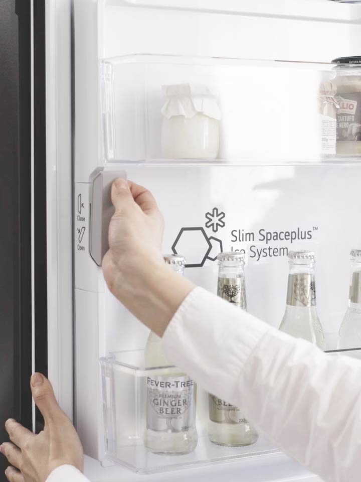 User opening the Slim SpacePlus Ice System compartment in an LG refrigerator	