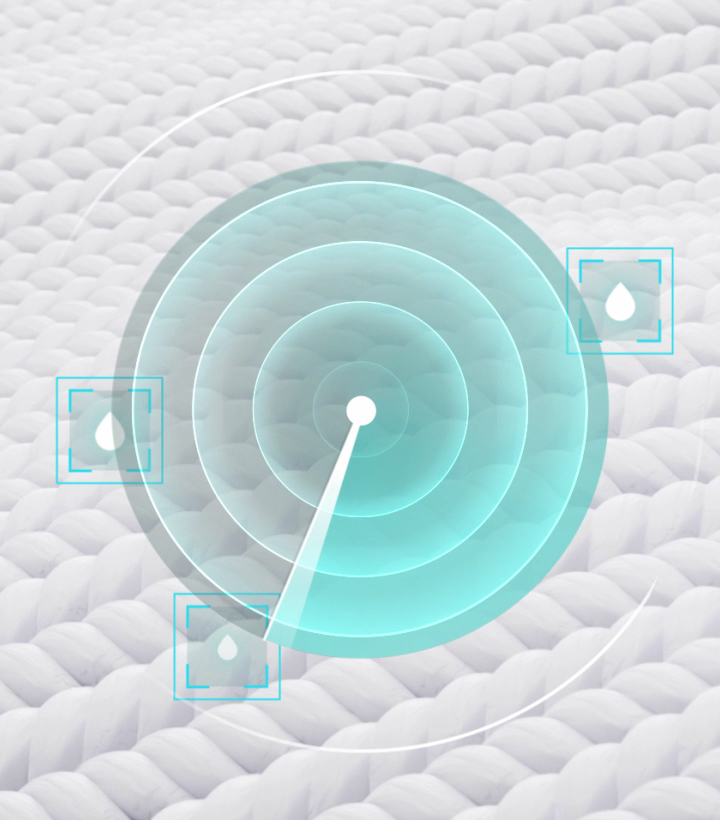 Close-up of an LG black steel dryer drum with a sensor dry strip and a hand reaching in to touch a white towel.