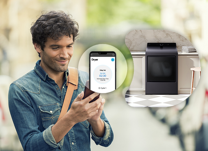 Black steel LG front-load dryer with a digital control panel and a smartphone displaying the ThinQ app interface.