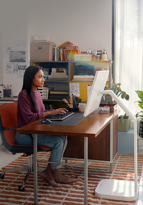 A woman is working using a LG Smart Monitor Swing in this image.
