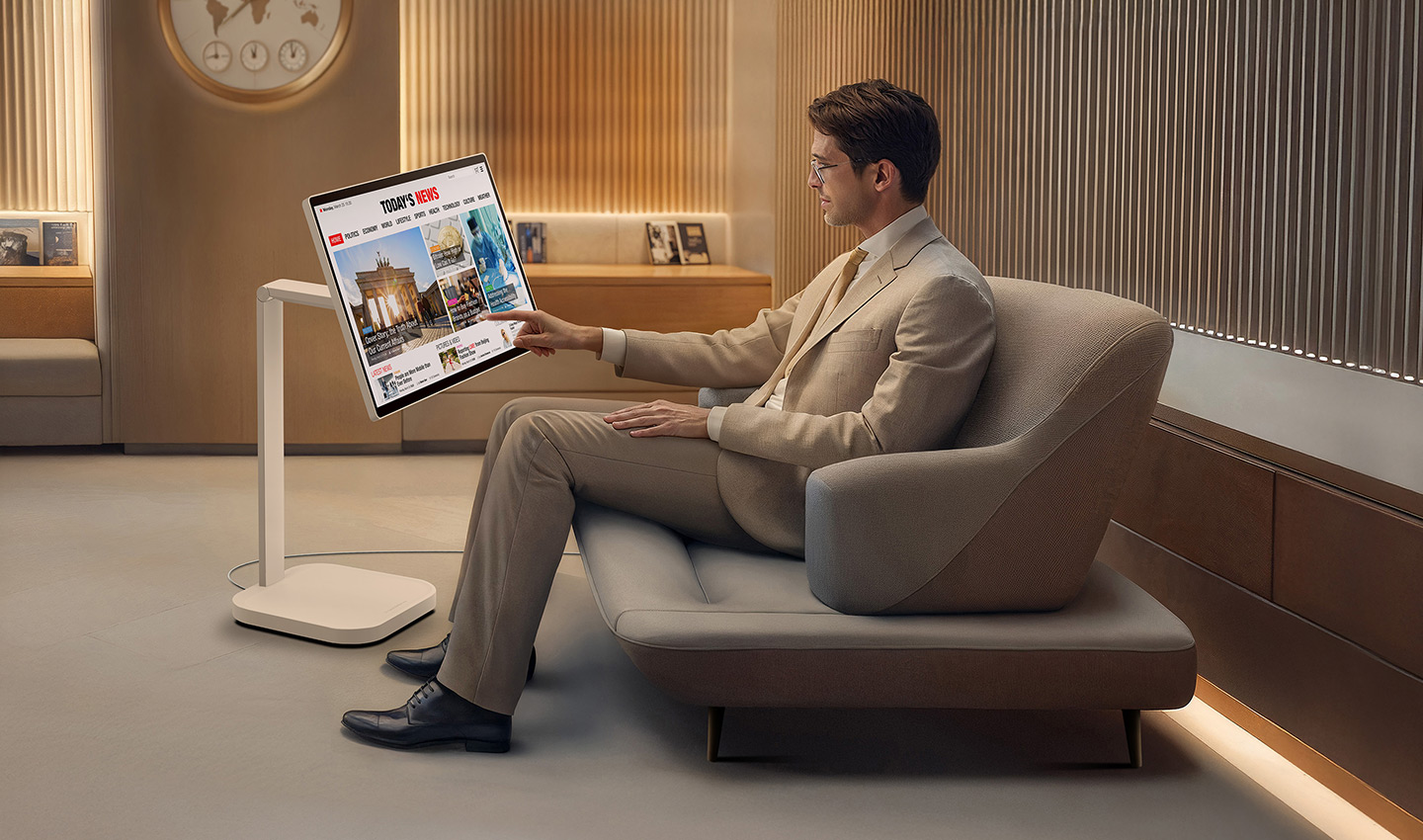 A man in the VIP lounge is reading the news on a LG Smart Monitor Swing.