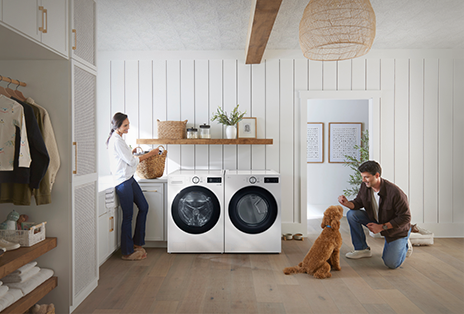 Couple heureux dans la salle de lavage avec son chien.
