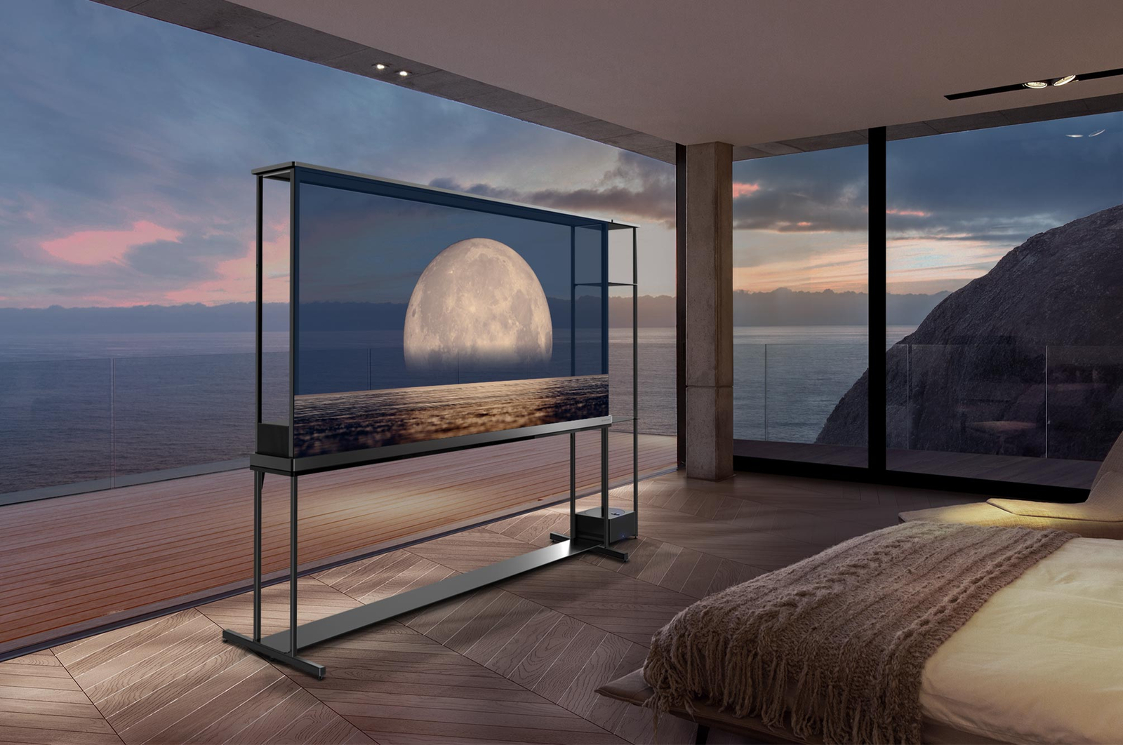 La SIGNATURE OLED T de LG affiche une lune représentée au-dessus d’une rive sur l’écran transparent. La SIGNATURE OLED T de LG est placée au milieu d’une pièce avec une vue latérale sur la falaise qui donne sur la mer. Sur la droite se trouve un lit et une longue chaise. 