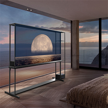 La SIGNATURE OLED T de LG affiche une lune représentée au-dessus d’une rive sur l’écran transparent. La SIGNATURE OLED T de LG est placée au milieu d’une pièce avec une vue latérale sur la falaise qui donne sur la mer. Sur la droite se trouve un lit et une longue chaise. 