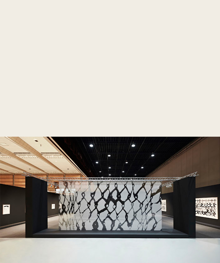 Art représenté sur un panneau transparent dans une salle d’exposition. 