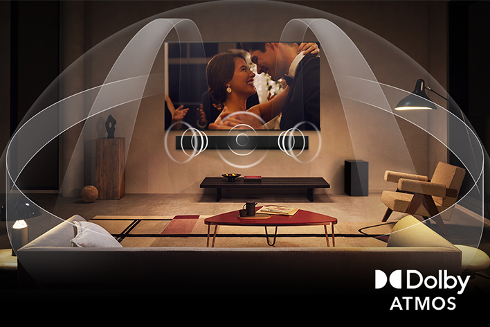 Salon confortable, éclairé, LG TV OLED et LG Soundbar. L’écran affiche un gros plan d’une guitare électrique jouée. Graphiques montrant Dolby Atmos remplir l’espace d’un Surround. Dolby Atmos au coin.