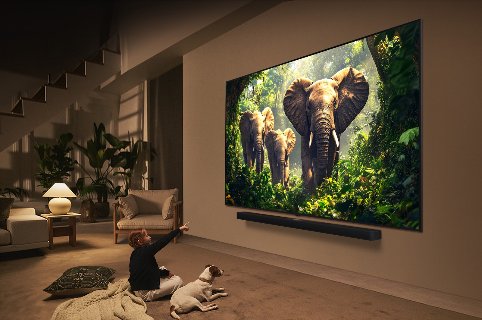 Une fille et un chien sont assis devant un LG QNED TV accroché au mur et représentant trois éléphants marchant vers l’extérieur, au-dessus d’une LG Soundbar. Le titre met en avant comment chaque action devient plus captivante sur un écran géant.
