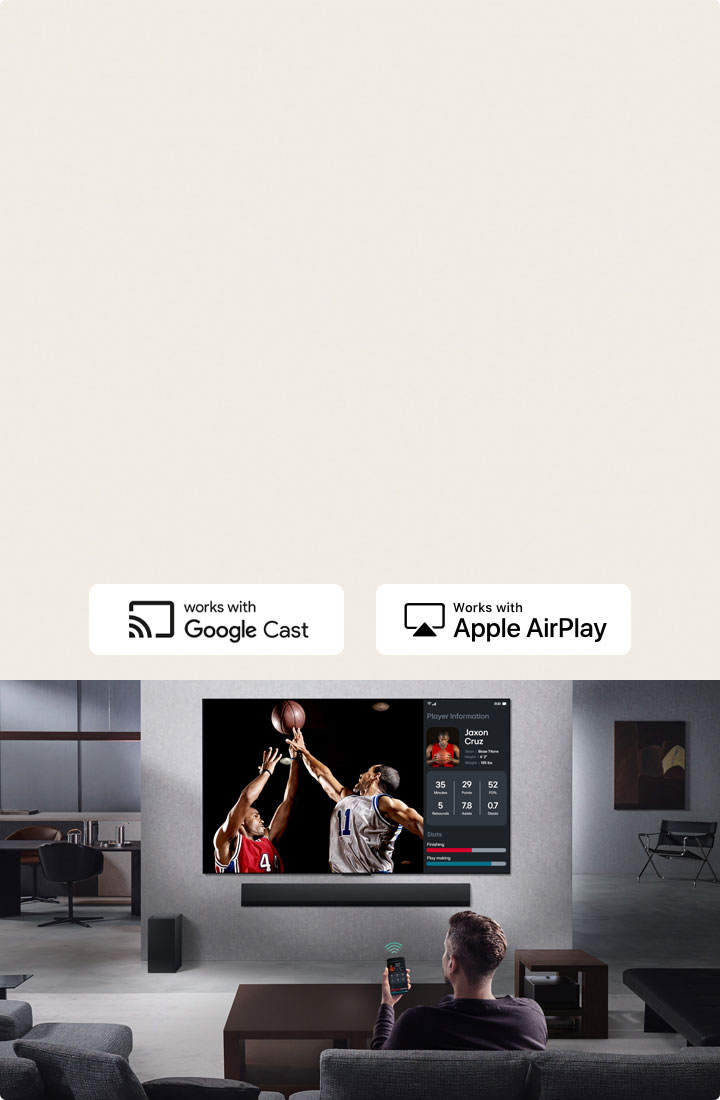 Personne dans son salon tenant son téléphone. Sur le téléphone se trouve une icône de transmission indiquant que l’écran du téléphone est reflété sur le téléviseur. Un match de basket-ball est diffusé sur le téléviseur. Sur le côté, un écran miroir affiche les statistiques des joueurs. 