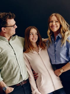 Portrait de famille de trois personnes debout ensemble et souriantes