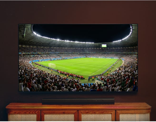 Téléviseur affichant une vue panoramique d'un stade de football pendant un match