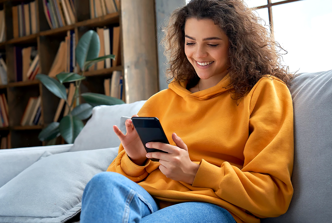LG lave-linge statut vérifié via l'app par une femme souriant sur un canapé illustre le support Smart Diagnosis.