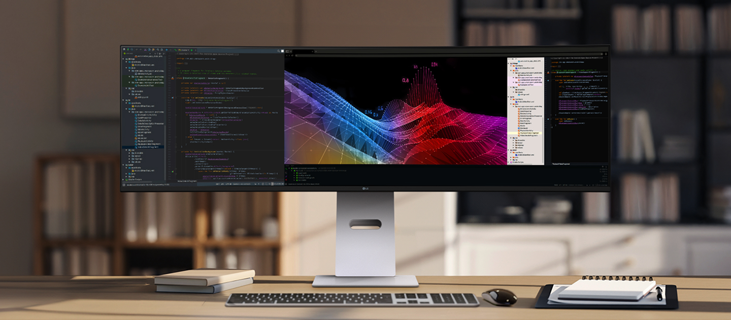 Un moniteur LG UltraWide posé sur un bureau dans une salle d’étude moderne, affichant des graphiques 3D colorés aux côtés d’un programme de codage.