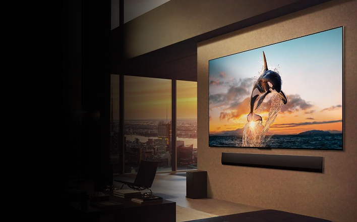 Un téléviseur LG monté au mur du salon affiche une vidéo d’une orque sautant hors de l’eau.