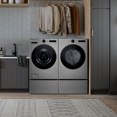L'ensemble lave-linge et sèche-linge frontal LG (WM5500HVA) en Acier Graphite, mettant en valeur son design premium et son intégration harmonieuse dans une buanderie moderne.
