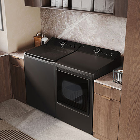 L'ensemble lave-linge et sèche-linge à chargement par le haut LG (DLEX8600BE) en Noir Acier, illustrant son design haut de gamme intégré harmonieusement dans une buanderie luxueuse avec marbre.