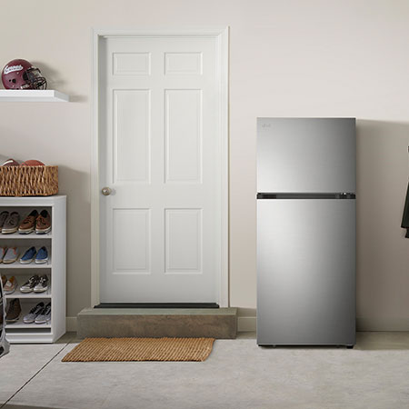 Le réfrigérateur à congélateur supérieur LG LT18S2100S de 28 po et 18 pi³ au fini inoxydable, présenté dans un garage.