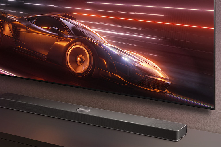 La barre de son LG et le téléviseur de LG sont présentés ensemble. Un jeu de voitures de course apparaît à l’écran. 	