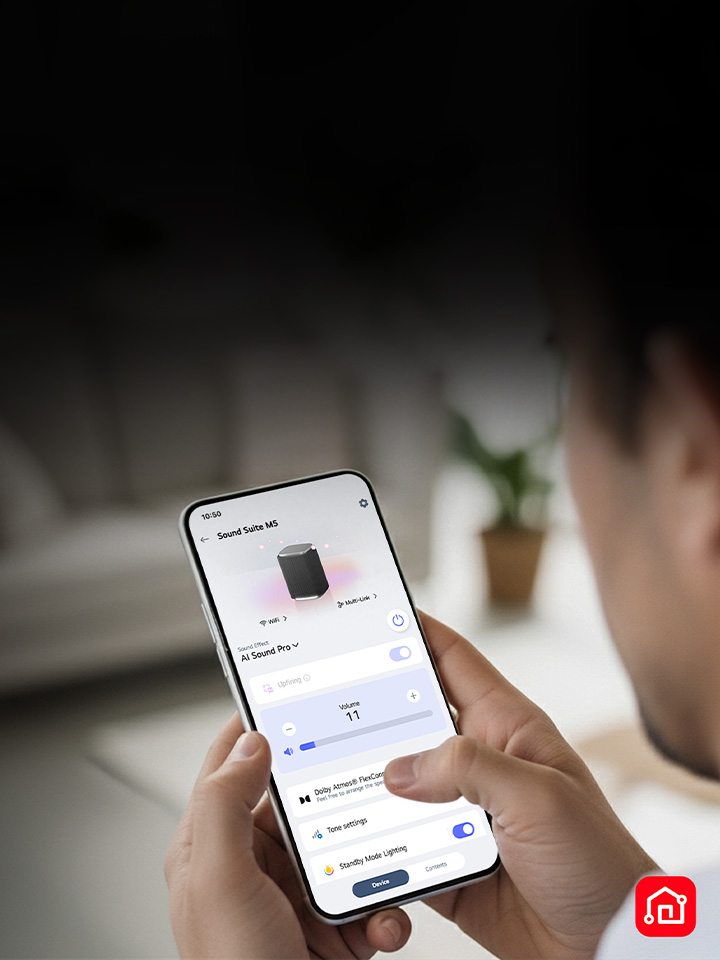 Une personne tient un téléphone intelligent sur lequel l’application LG ThinQ est ouverte, montrant un contrôle facile du système Sound Suite de LG.