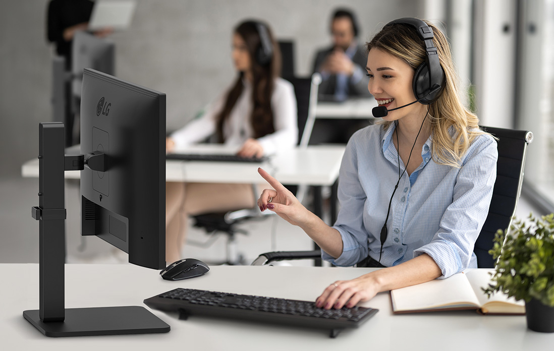 Une femme portant un casque d’écoute parlant à un client dans un centre d’appels.