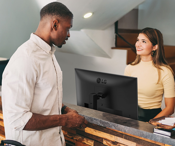 Une réceptionniste discute avec un client à la réception.