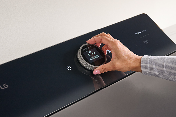 Gros plan du panneau de commande numérique noir d'une sécheuse LG avec écran LCD et bouton rotatif.