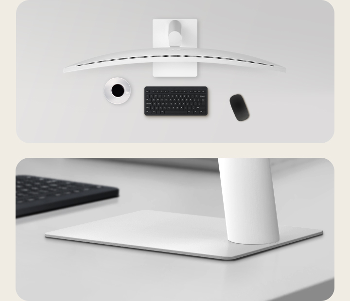 Vue de dessus et gros plan d’un moniteur incurvé sur un bureau épuré avec un support blanc, un clavier noir, une souris et une tasse de café.