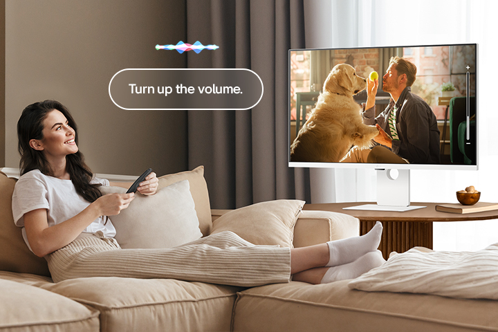Une femme augmente le volume du LG Smart Monitor à l’aide du Magic Remote.