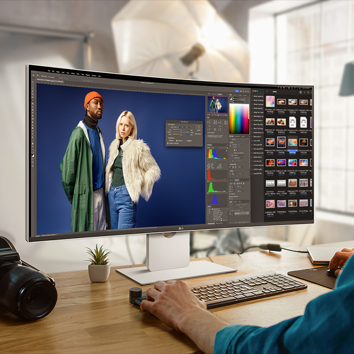 Un homme utilise un programme de design sur le moniteur UltraFine, avec un appareil photo placé à côté de l’écran.