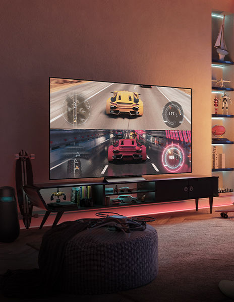 Un téléviseur avec un écran de jeu allumé est placé dans un espace intérieur sombre.