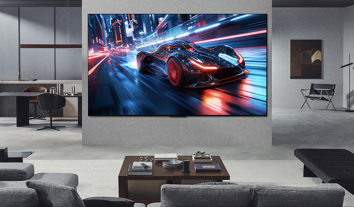 غرفة معيشة تحتوي على تلفزيون LG Ultra Big TV ضخم مُثبت على الحائط، يُعرض على شاشته سباق سيارات. وبفضل مقاس الشاشة الكبير، تبدو التجربة أكثر غمرًا وواقعية.