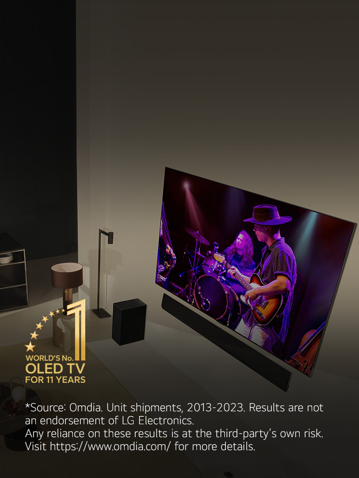 An overhead perspective of a man and woman watching a concert on a large OLED TV in a modern apartment. The "World's number 1 OLED TV for 11 Years" emblem is in the image. A disclaimer reads: "Source: Omdia. Unit shipments, 2013 to 2023. Results are not an endorsement of LG Electronics. Any reliance on these results is at the third party’s own risk. Visit https://www.omdia.com/ for more details."