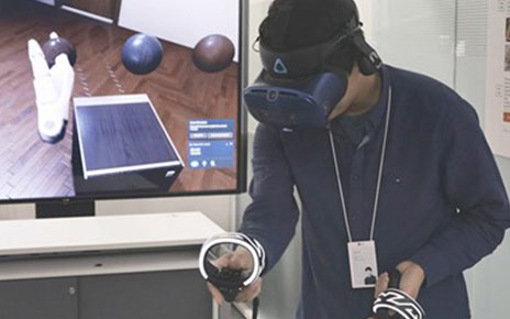 One of LG’s digital designers using a VR headset and remote control to better understand a product’s ability to harmonize with the environment.