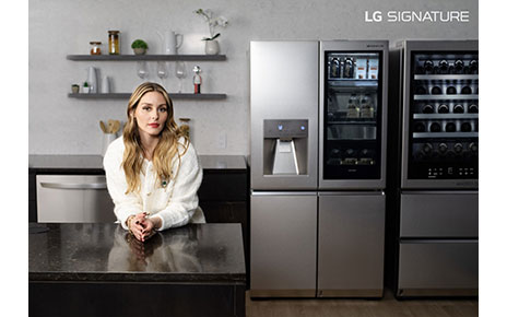 Olivia Palermo is leaning on the LG SIGNATURE Washer/Dryer Combo, positioned between a hanger and laundry trolley